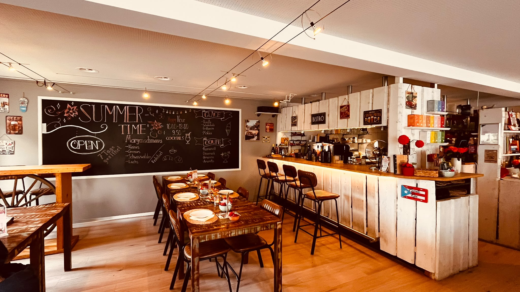 Innenraum des Bistro Café Füürio mit Bar, Tischen und Wandtafel